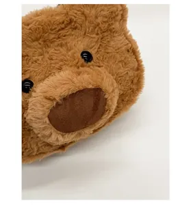 Close-up of fluffy brown plush bear bag showing 3D cartoon facial details and soft texture