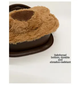 Detail of plush bear bag featuring a reinforced smooth brown leather base for durability