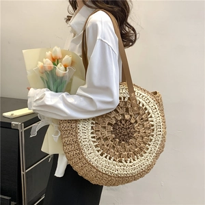 Large circular woven straw shoulder bag with two-tone design and long leather straps