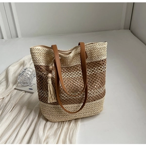Détail du sac de plage en paille tressée avec rayures contrastées et lanière cuir