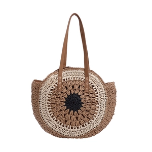 Large woven straw shoulder bag with colorful concentric circles and brown leather straps