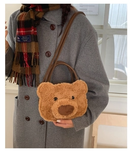 Detail of cute brown plush bear handbag with soft curly faux fur and long shoulder strap