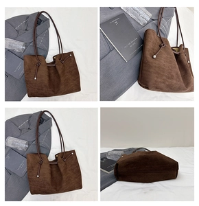 Detail view of large brown suede tote bag with drawstring knots and metal accents