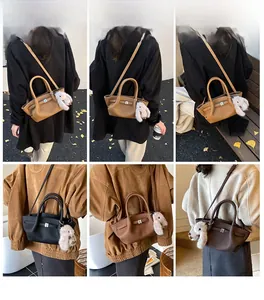 Litchi pattern leather bucket bag with metal lock detail and rabbit pendant on a model
