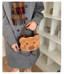 Detail of plush brown bear handbag with leather handle and shoulder strap texture