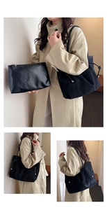 Detail of black faux suede tote bag and matching clutch set with side drawstring design