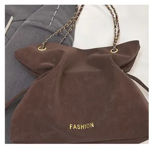 Close-up of matte dark brown tote bag with chain strap and gold fashion logo