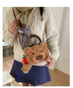 Close-up of fluffy brown bear plush handbag with a cute carrot charm accessory