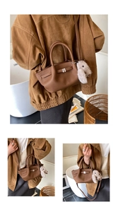 Detail of brown lychee leather handbag with silver lock and plush bunny charm