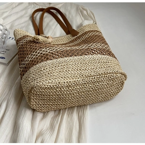Détails de texture du sac cabas rayé avec poignées en cuir marron et pompon décoratif