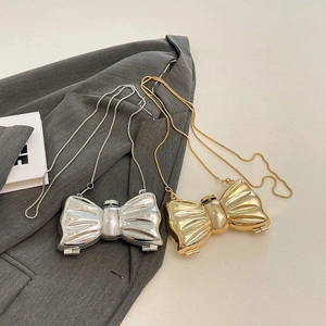 Chic bow-shaped acrylic evening bag with metallic chain strap in gold and silver finishes