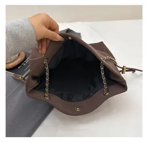 Top view of spacious brown matte bucket bag interior with black lining and gold chain