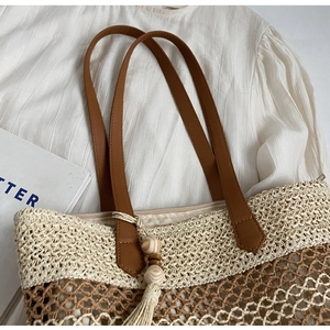 Détail du sac de plage tissé avec bandoulière en cuir et pompon en perles de bois