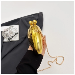 Detail of heart-shaped gold evening clutch bag with polished finish and ball clasp