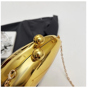 Detail of gold oval evening clutch with round metal clasps and fine metal chain strap