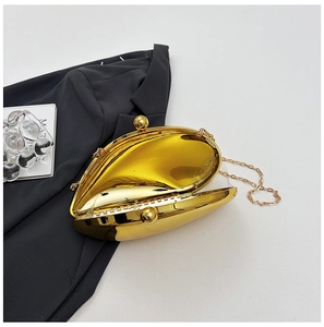 Close-up of a gold shell-shaped evening clutch with metallic mirror finish and chain