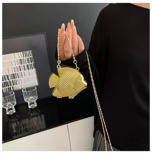 Dettaglio ravvicinato di una borsa da sera a forma di pesce d'oro in metallo con squame