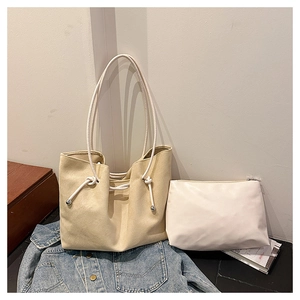 Detail of beige canvas tote bag with thick rope handles and a white zipper pouch insert