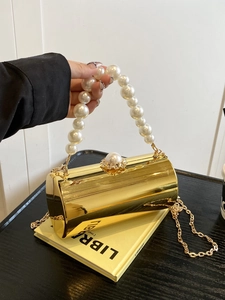 Détail du sac de soirée cylindrique doré avec poignée perle et bandoulière chaîne