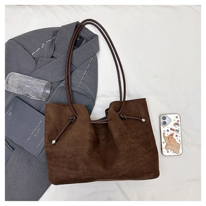 Brown faux suede tote bag with metal ball detail and tied knots for daily commute