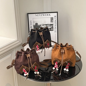 Sac seau vintage en daim noir et marron avec cordon de serrage et pompon décoratif
