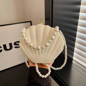 Elegant white shell-shaped evening bag with large pearl handle and crossbody strap