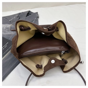 Detail view of large brown suede bucket bag with inner leather pouch and drawstring