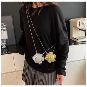 Dettaglio delle mini borse da sera a forma di pesce in oro e argento con squame