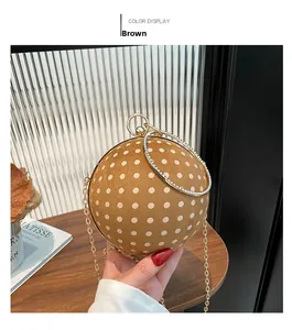 Detailed view of the brown polka dot sphere handbag with a crystal ring handle