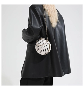 Close-up of polka dot ball bag with rhinestone ring handle and gold chain strap