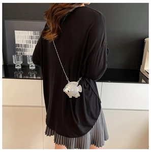 Dettaglio mini borsa da sera argento a forma di pesce con catena indossata da modella