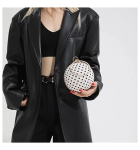 Close-up of golden rhinestone handle on a spherical polka dot fashion evening handbag