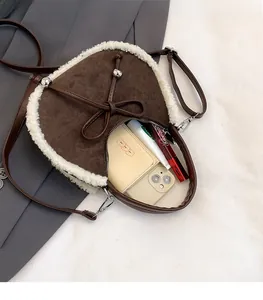 Detailansicht des Innenraums der braunen Wildleder-Mondtasche mit Plüsch und Schleife