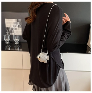 Dettaglio borsa da sera a forma di pesce in metallo argento con texture a scaglie