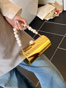 Détail du sac de soirée cylindre doré avec poignée en perles et fermoir en strass