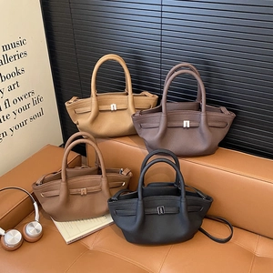 Minimalist leather bucket handbags in four colors displayed on a sofa for women