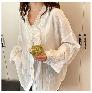 Vista dettagliata di una borsa da sera dorata a forma di pesce con texture a scaglie