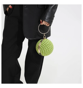 Detail of green polka dot sphere handbag with luxury rhinestone circular handle