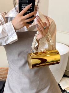 Détail du sac de soirée cylindre doré avec poignée en perles et fermoir décoré