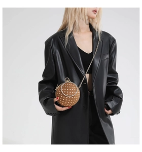 Polka dot ball handbag with gold chain strap and rhinestone ring handle on model