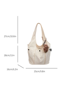 Chic off-white canvas tote bag with black snap pockets and brown bear charm