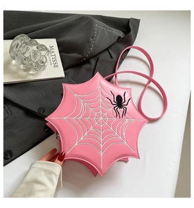 Detail of pink spider web PU leather crossbody bag with 3D spider decor on grey suit