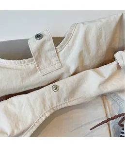 Detail of premium silver magnetic snap closures on beige fabric shoulder bag