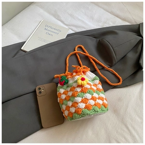 Detail of crochet bucket bag featuring strawberry ornaments and contrast stitch texture