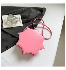 Pink star-shaped PU leather crossbody bag displayed with a book and blazer in a flat lay