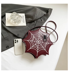 Detail of burgundy PU leather crossbody bag with white spider web embroidery and 3D spider