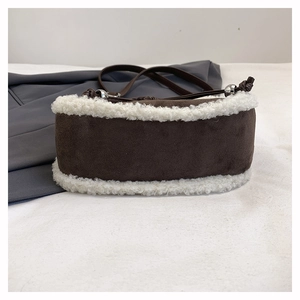 Details der braunen Wildleder-Halbmondtasche mit weißem Kunstfellbesatz und Silberring