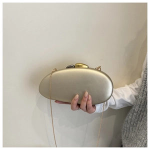 Detail view of champagne gold oval evening clutch bag with mineral-shaped clasp and chain strap