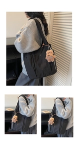 Detail of black nylon tote bag with front pocket, metal snap and cute bear charm