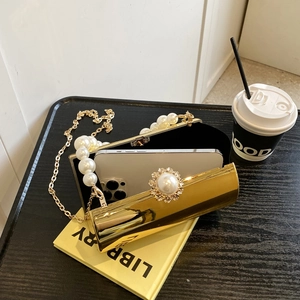 Détail de la pochette de soirée dorée avec anse en perles montrant l'espace pour téléphone